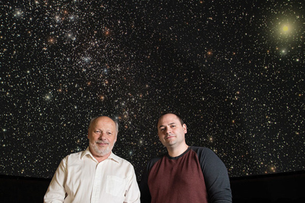 Researchers Wiescher and Robertson with backdrop of a star field